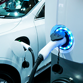 Photograph of an electric vehicle charger and an electric vehicle.