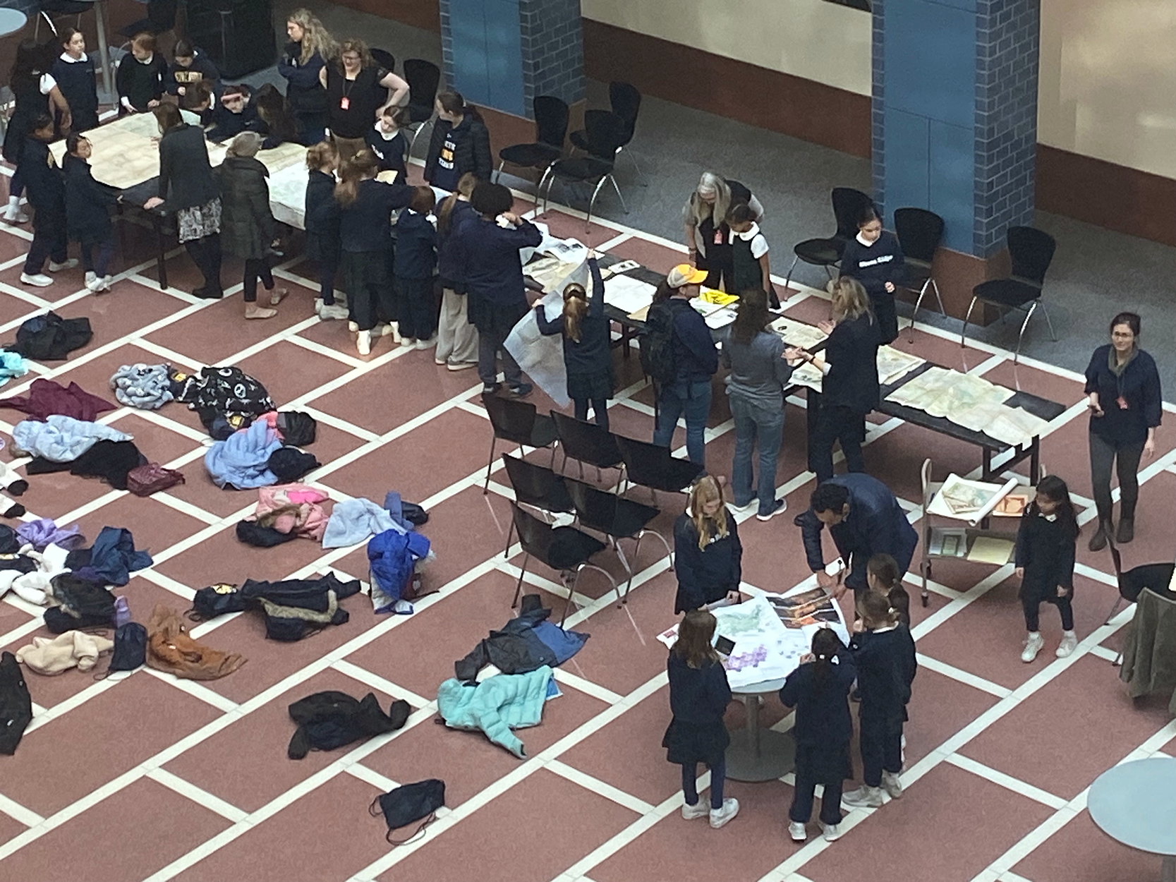 Picture of students looking at maps on a table