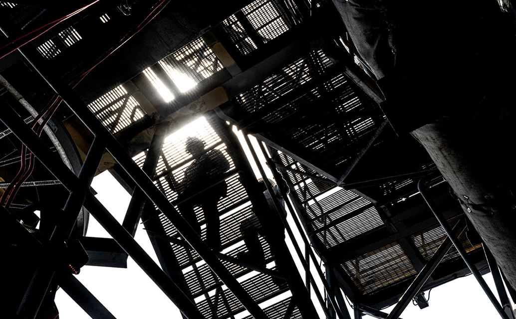 Image of workers climbing stairs on an oil platform.